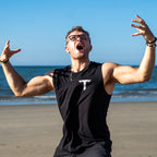 Teminite Logo Tank Top – Black, worn on the beach, arms raised